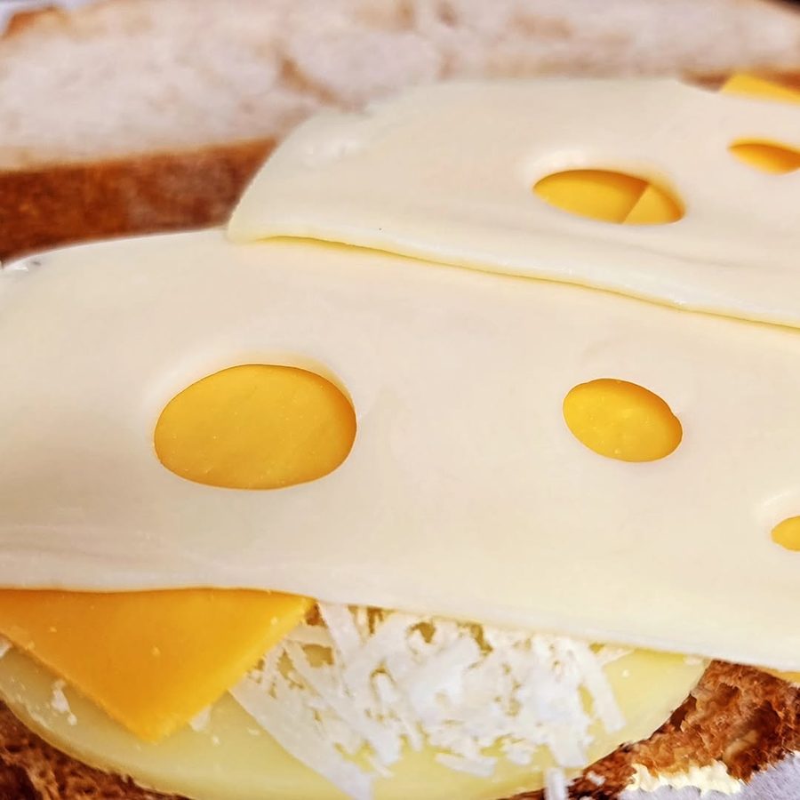Close-up of Swiss and cheddar slices on a loaf before toasting